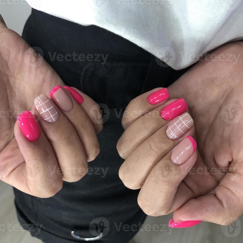 manicure rosa feminina na moda elegante. mãos de uma mulher com manicure rosa nas unhas foto