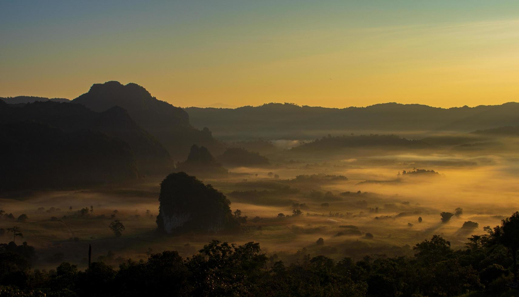 hora dourada sobre montanhas e nevoeiro foto