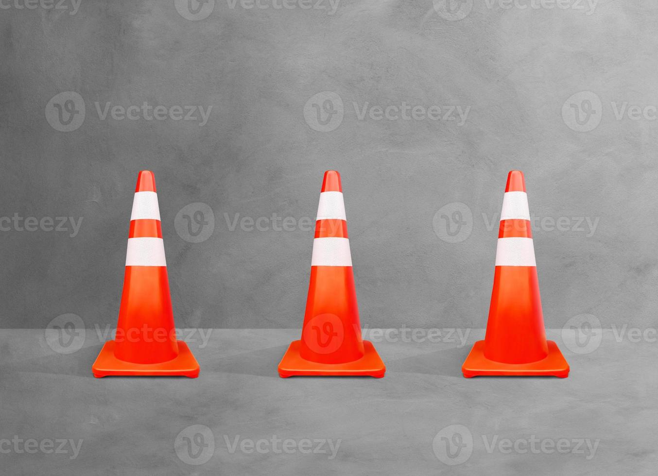 cones de trânsito, postes branco-laranja, isolados no chão de cimento. foto