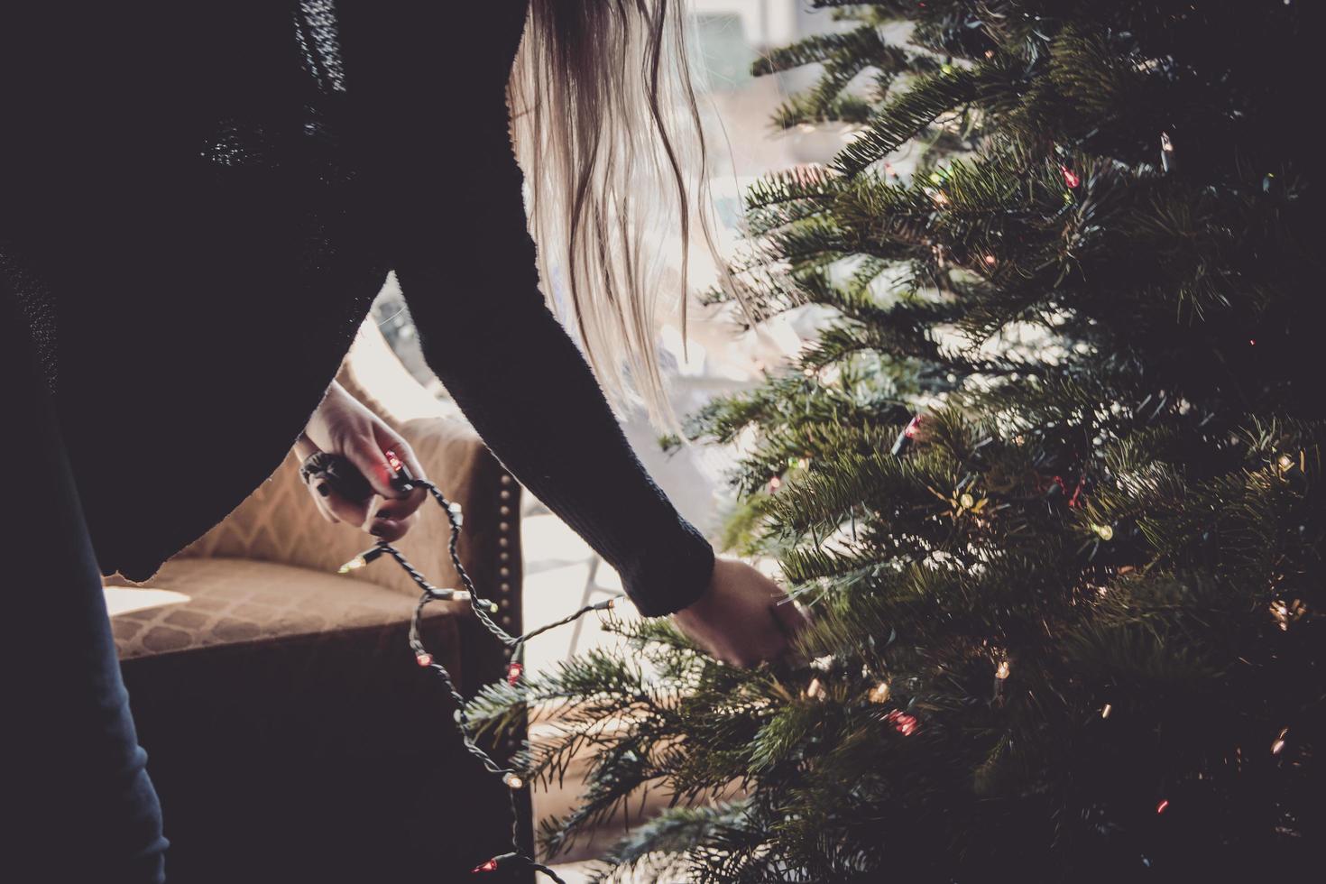 mulher decorando árvore de natal foto