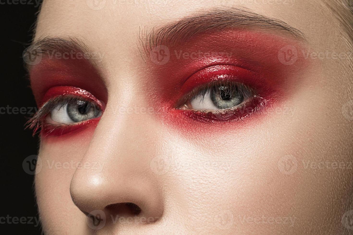 lindo rosto feminino jovem com maquiagem vermelha brilhante foto