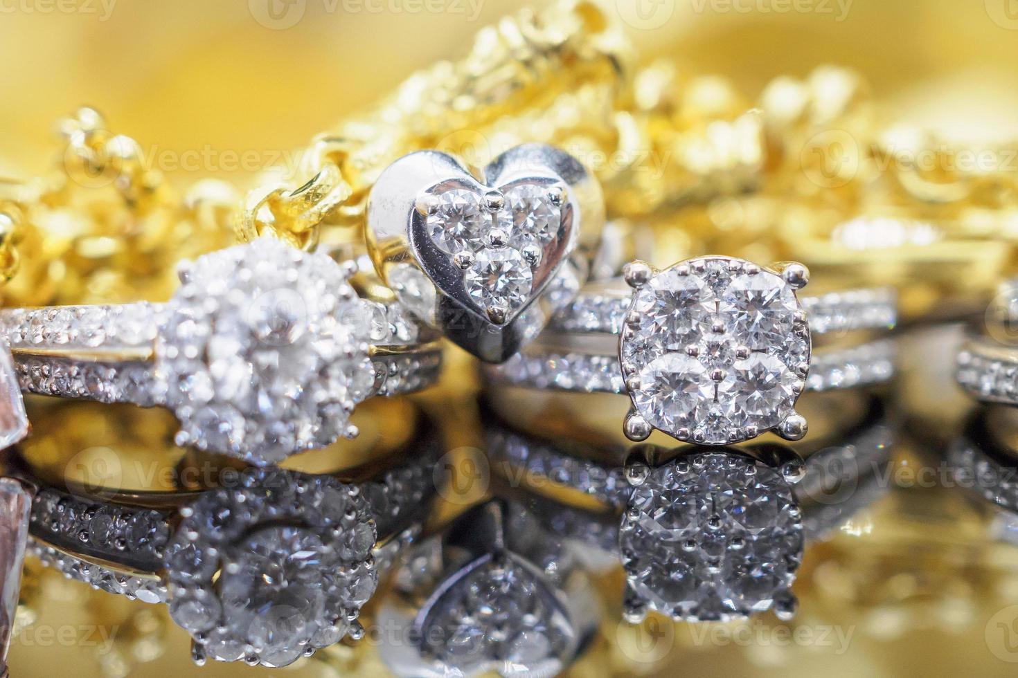 anéis de diamante de joias de ouro de luxo com reflexo no fundo preto foto