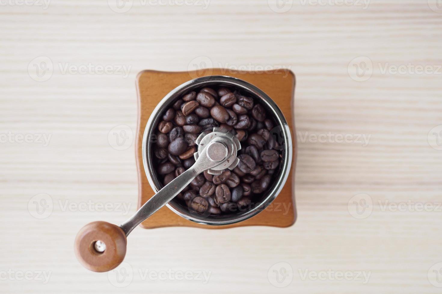 moedor de café manual vintage com grãos de café torrados foto