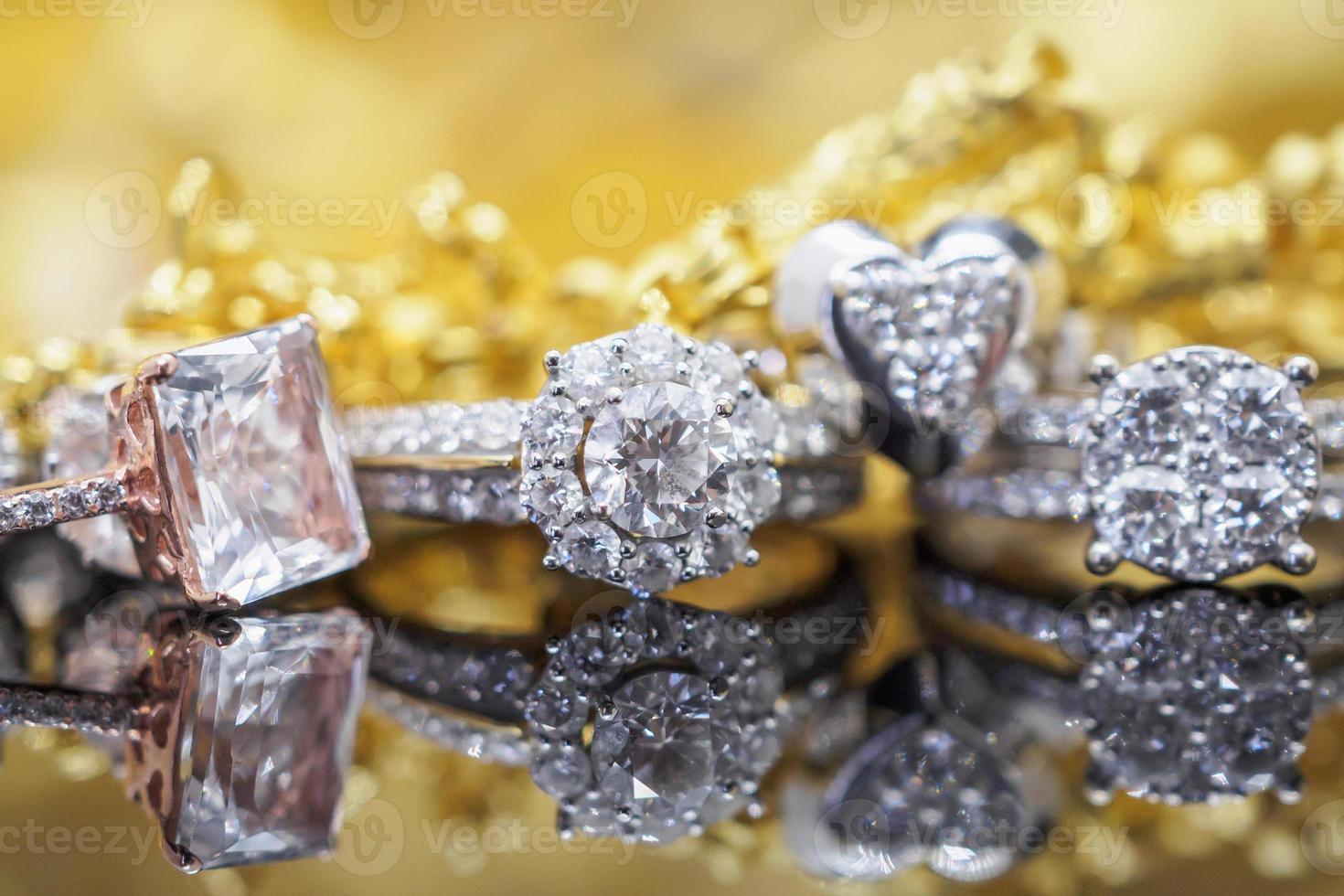 anéis de diamante de joias de ouro de luxo com reflexo no fundo preto foto