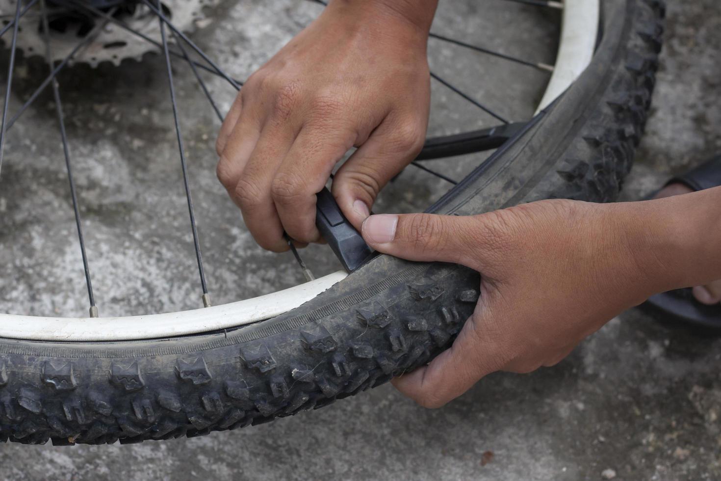 a mão de um mecânico está trocando os pneus da bicicleta. foto