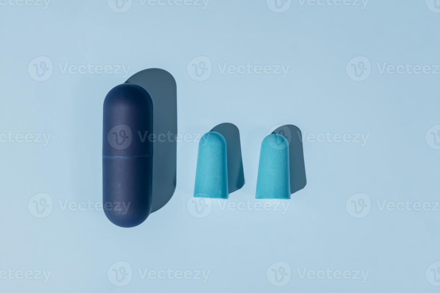 tampões de ouvido azuis feitos de espuma para dormir confortável em fundo azul. conceito de insônia, postura plana foto