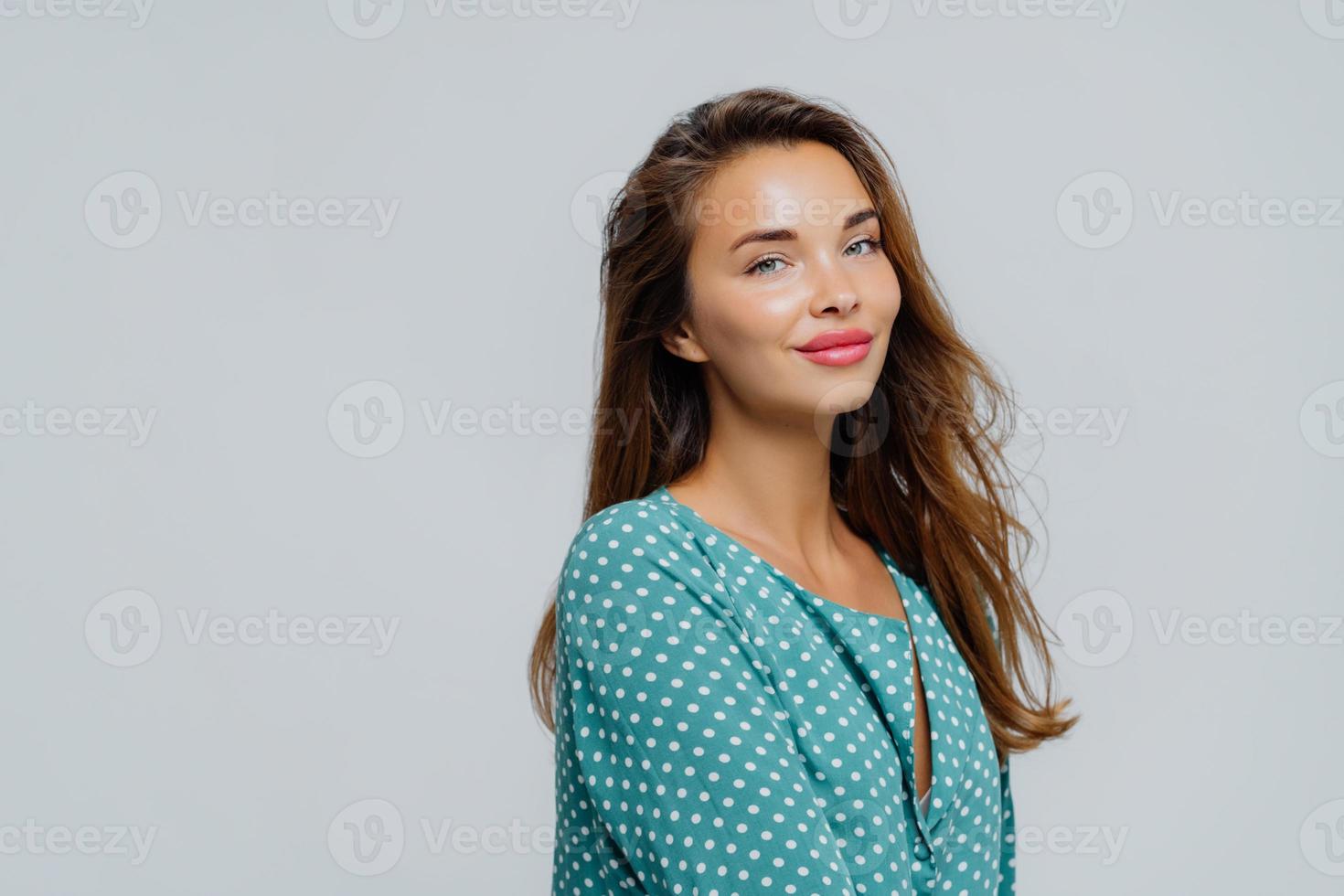 foto de perfil de mulher muito satisfeita usa maquiagem, batom rosado, vestido com blusa de bolinhas, tem pele saudável, posa contra um fundo branco com espaço em branco para seu anúncio ou promoção.