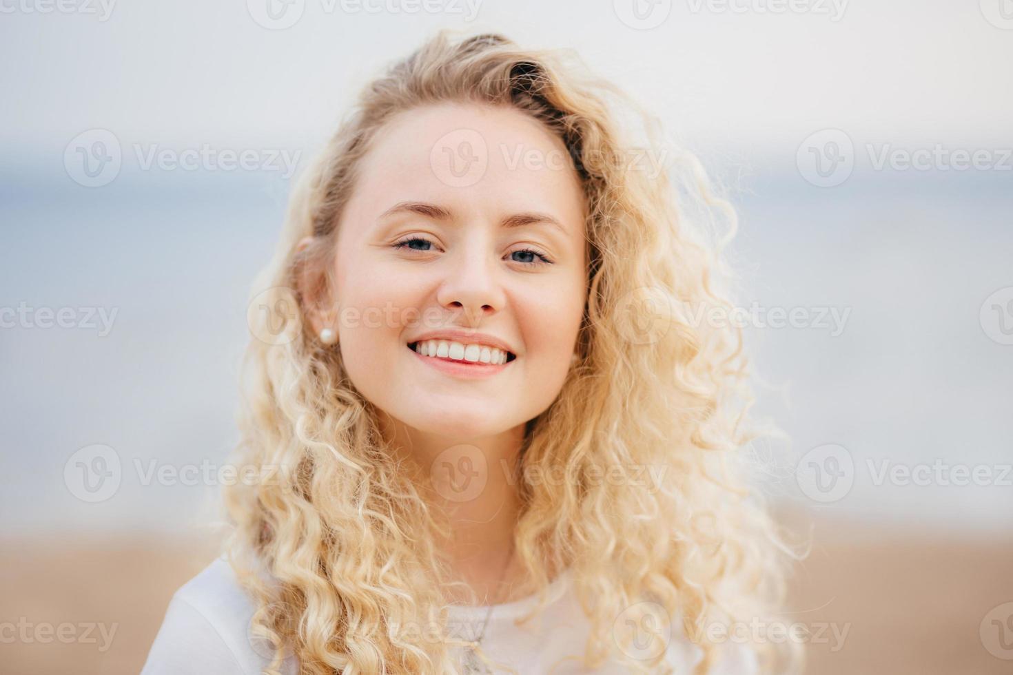 tiro na cabeça de mulher bonita com sorriso amigável, tem pele saudável, estar de bom humor após descanso inesquecível no país resort com namorado, tem aparência atraente. pessoas, beleza, conceito de estilo de vida foto