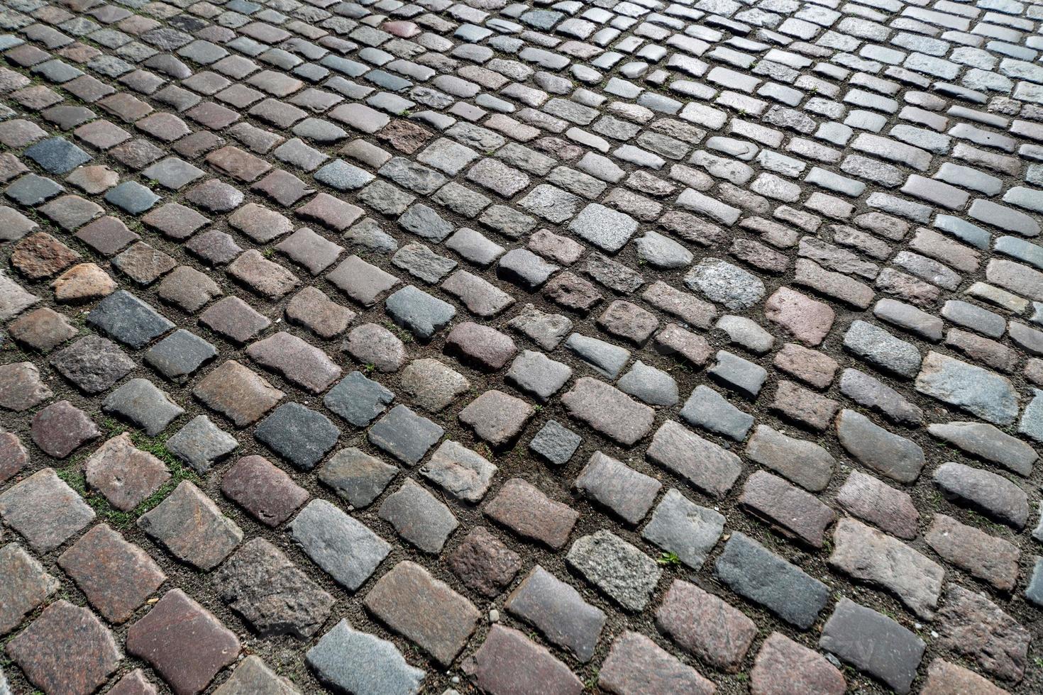 textura de azulejos. padrão de paralelepípedos alemão antigo no centro da cidade. pequenas pedras de granito para pavimentação. pavimentos cinzas antigos. foto