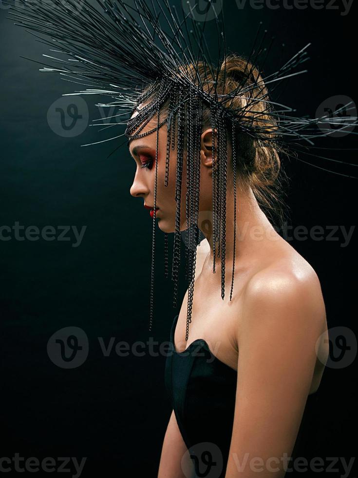 retrato de uma jovem mulher bonita como bruxa com lábios vermelhos e coroa preta sobre fundo escuro. beleza negra negra, conceito de halloween foto