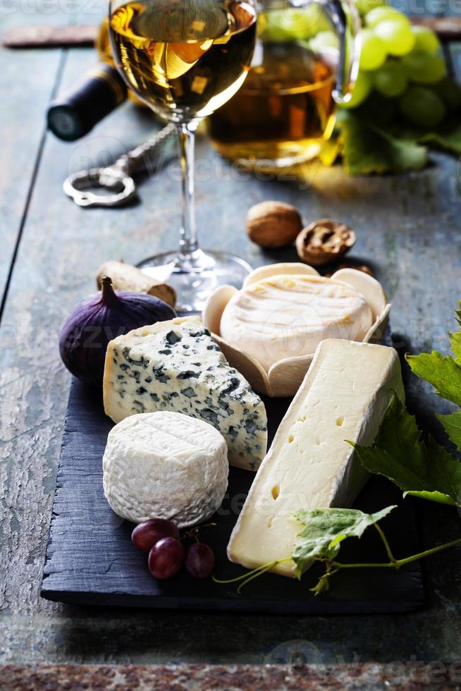 vários tipos de queijo e vinho branco foto