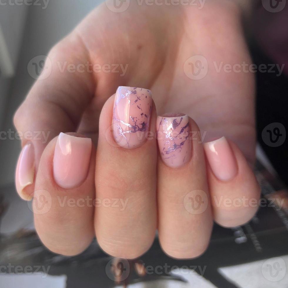 manicure rosa feminina na moda elegante. mãos de uma mulher com manicure rosa nas unhas foto