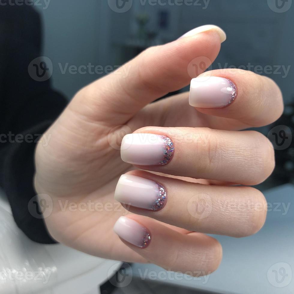 manicure rosa feminina na moda elegante. mãos de uma mulher com manicure rosa nas unhas foto