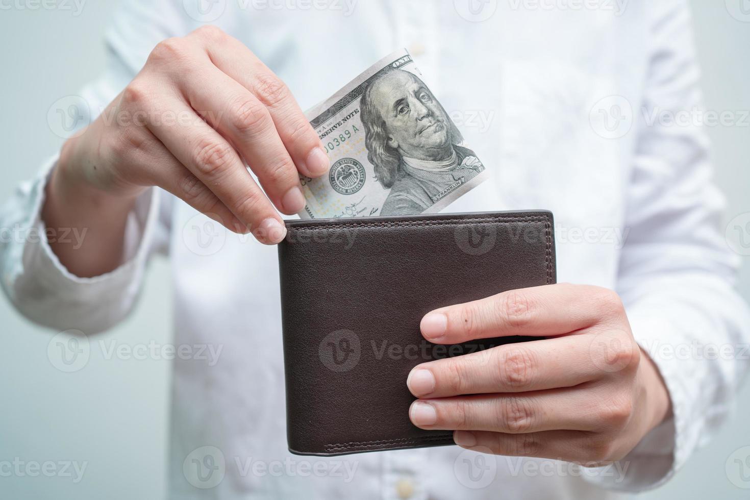 feche a mão masculina abra a wallet.he tem muito dinheiro dólar na carteira. conceito de negócio financeiro. foto
