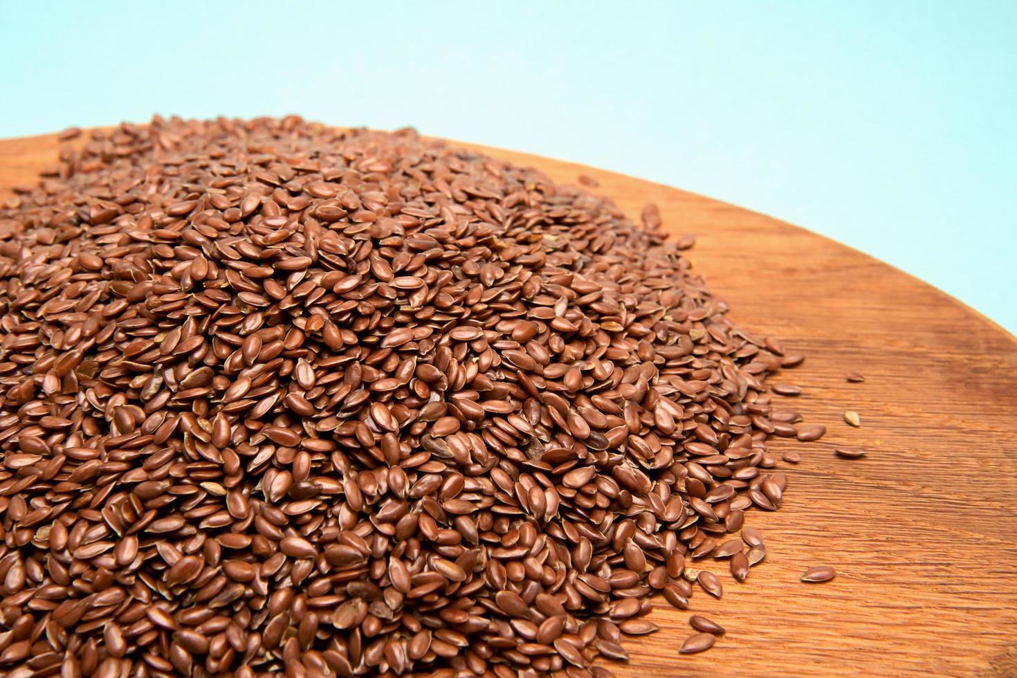 sementes de linho em uma pilha em uma bandeja de madeira. conceito de comida saudável foto