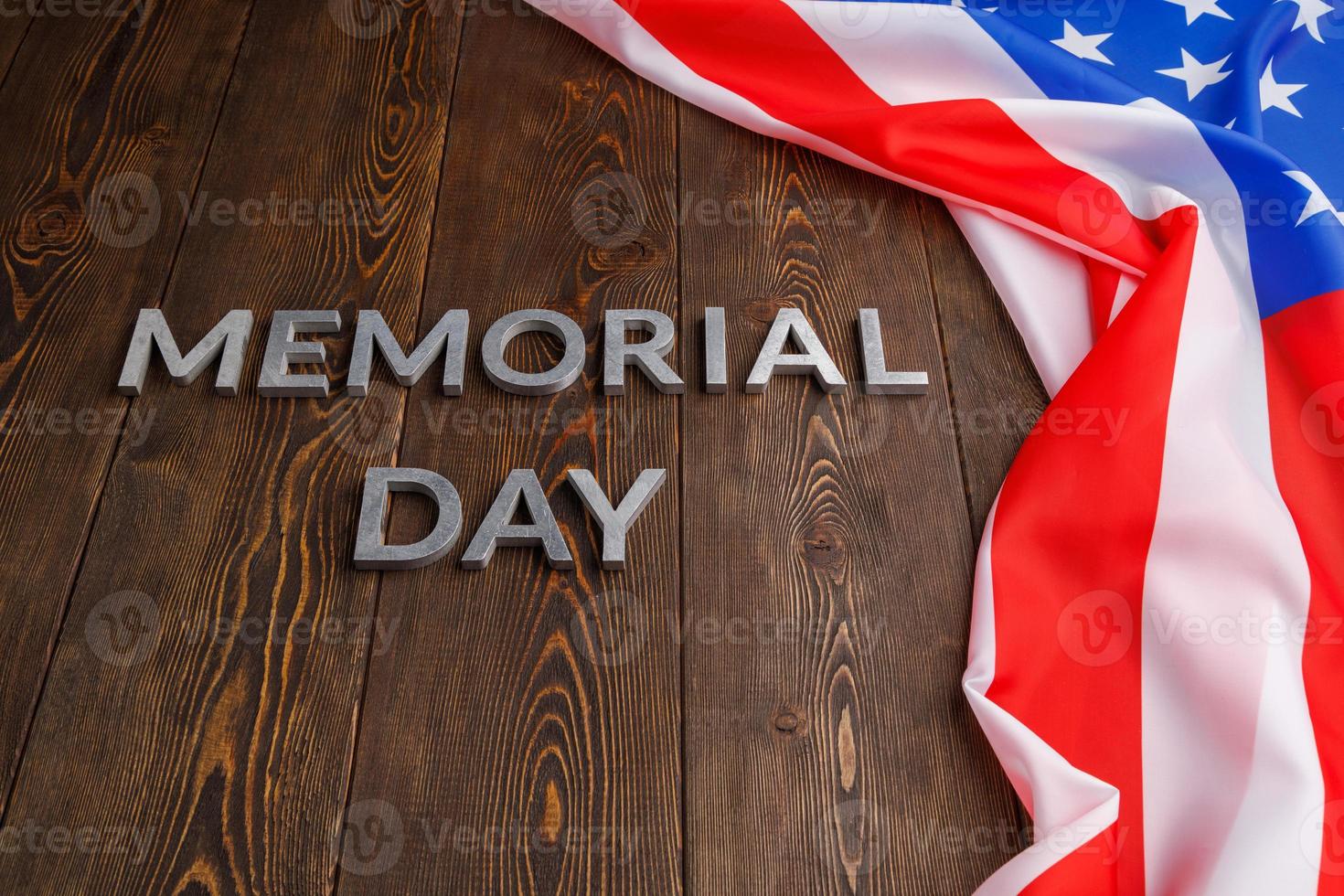 as palavras memorial day colocado com letras de metal prateado na superfície da placa de madeira com bandeira dos eua amassada foto