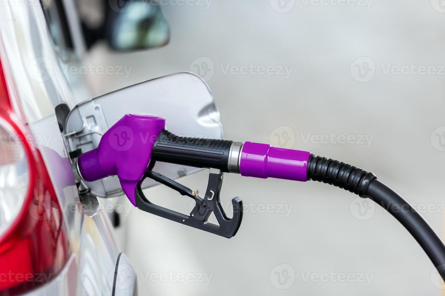 reabastecimento de carro prateado no posto de gasolina, o conceito de energia de combustível foto