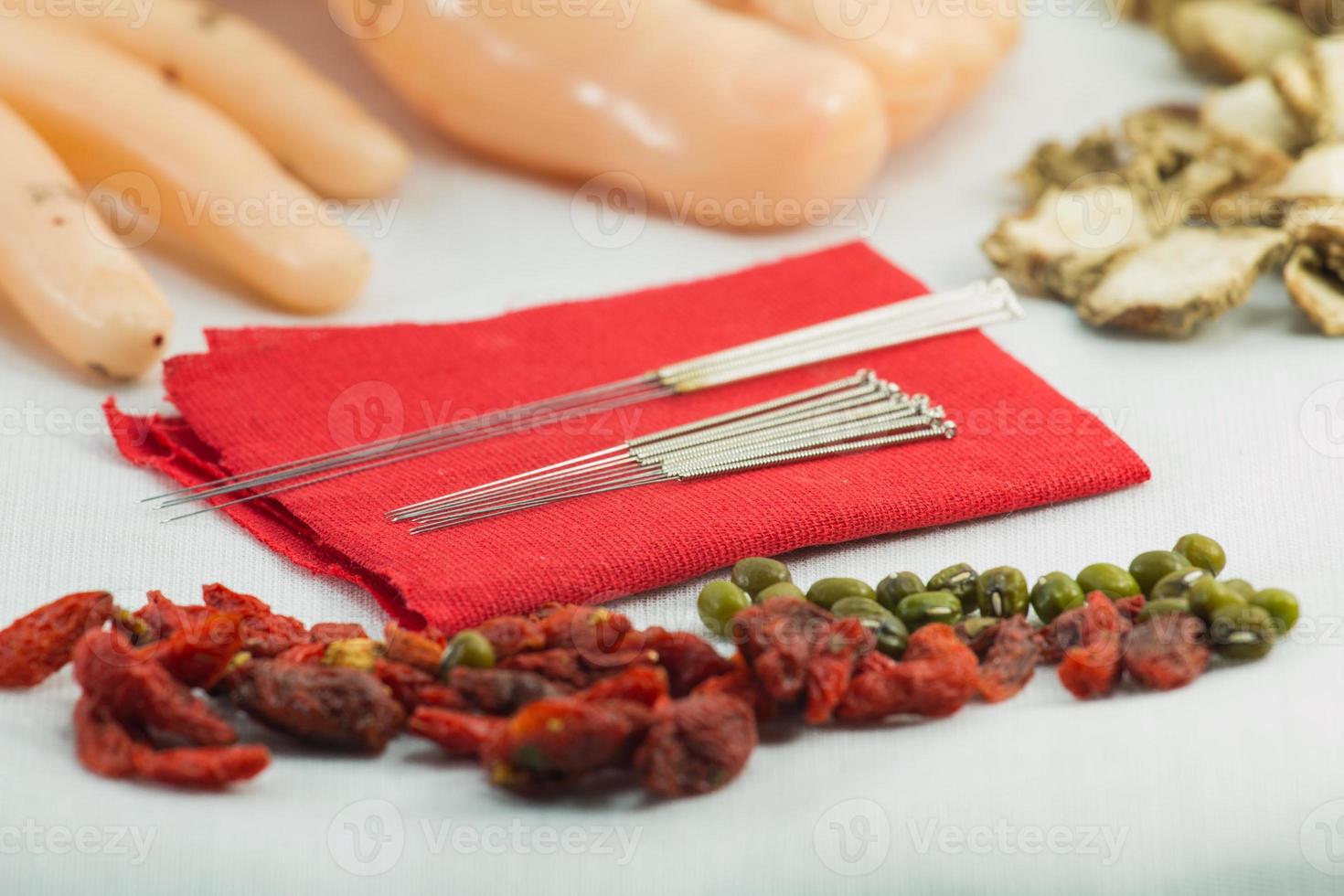fechar agulhas de acupuntura chinesa em pano vermelho com meridiano foto