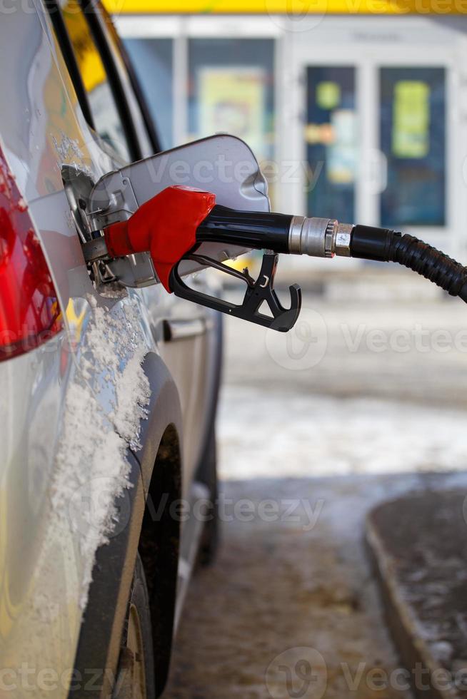 reabastecimento de carro metálico prateado no posto de gasolina do dia de inverno - close-up com foco seletivo e fundo desfocado foto