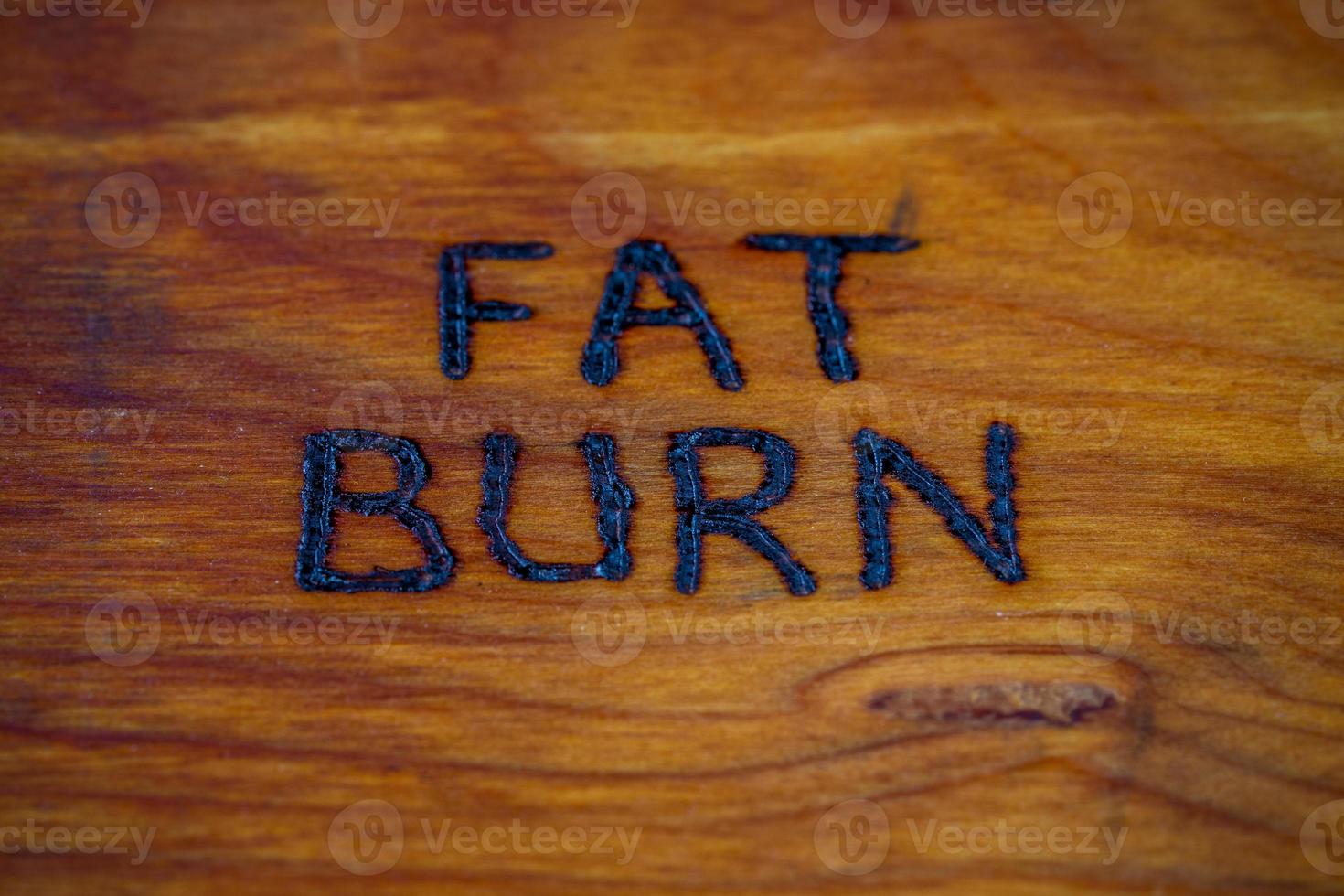 as palavras queima de gordura handritten na superfície de madeira com recuperador de calor foto