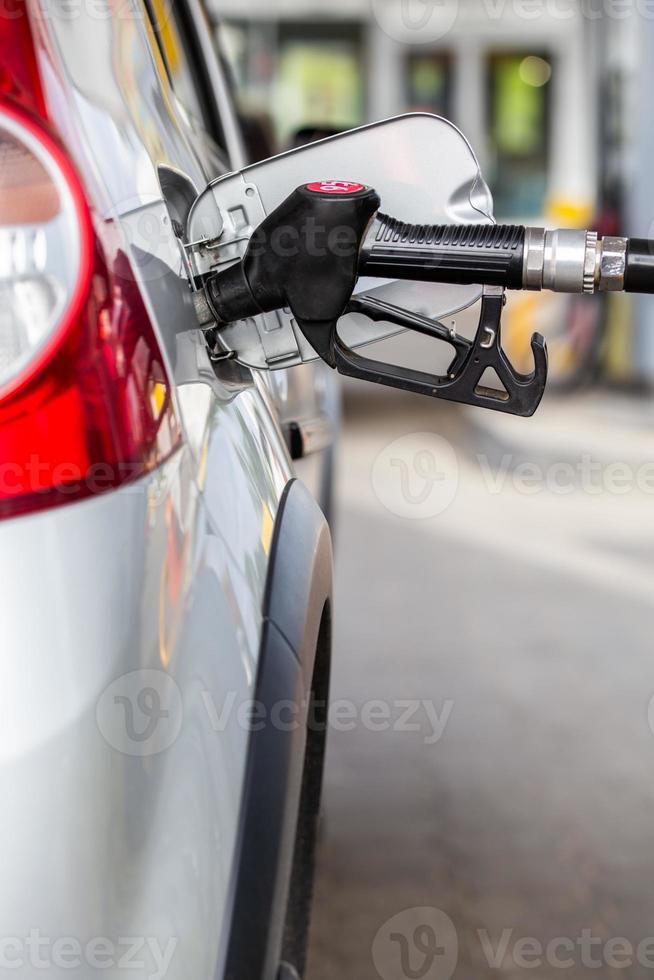 carro metálico cinza reabastecimento no posto de gasolina - closeup com foco seletivo foto