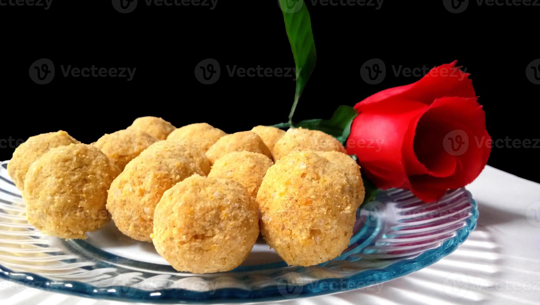 doce de dar água na boca - besan laddoo feito de farinha de grama torrada, ghee, frutas secas e açúcar, servido em um prato foto