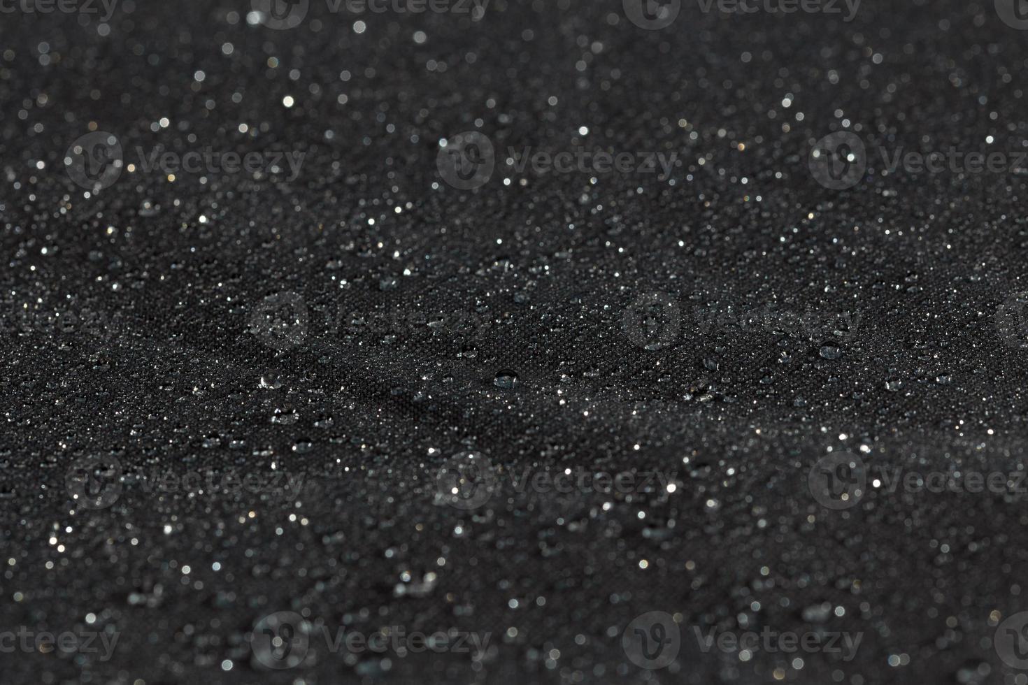 pano liso hidrofóbico impermeável cinza escuro com gotas de chuva, fundo de close-up foto