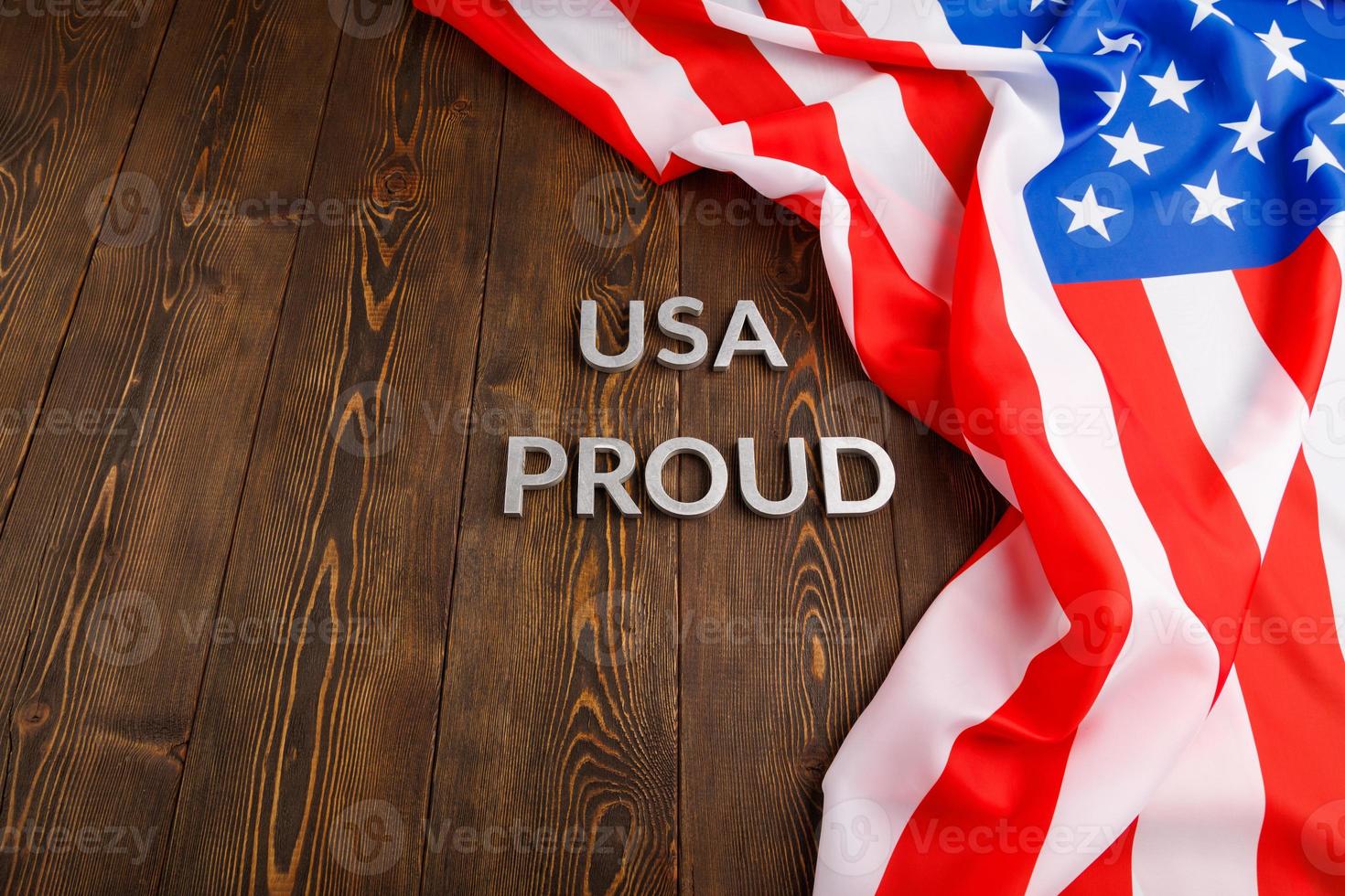 palavras eua orgulhoso colocado com letras de metal prateado na superfície de madeira marrom com bandeira dos estados unidos da américa foto