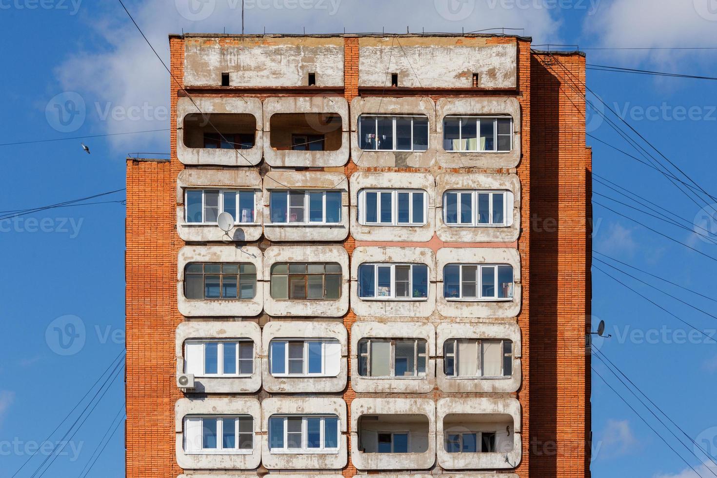 edifício residencial de condomínio de torre de concreto e tijolo típico da meia-russa no fundo do céu azul foto