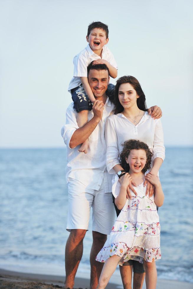 feliz jovem família se divertir na praia foto