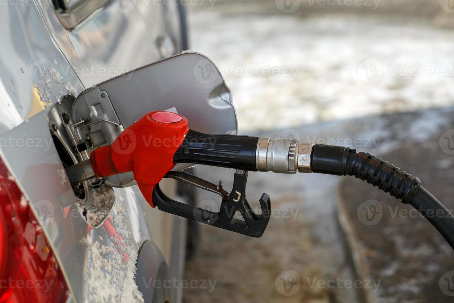 reabastecimento de carro metálico prateado no posto de gasolina do dia de inverno - close-up com foco seletivo e fundo desfocado foto