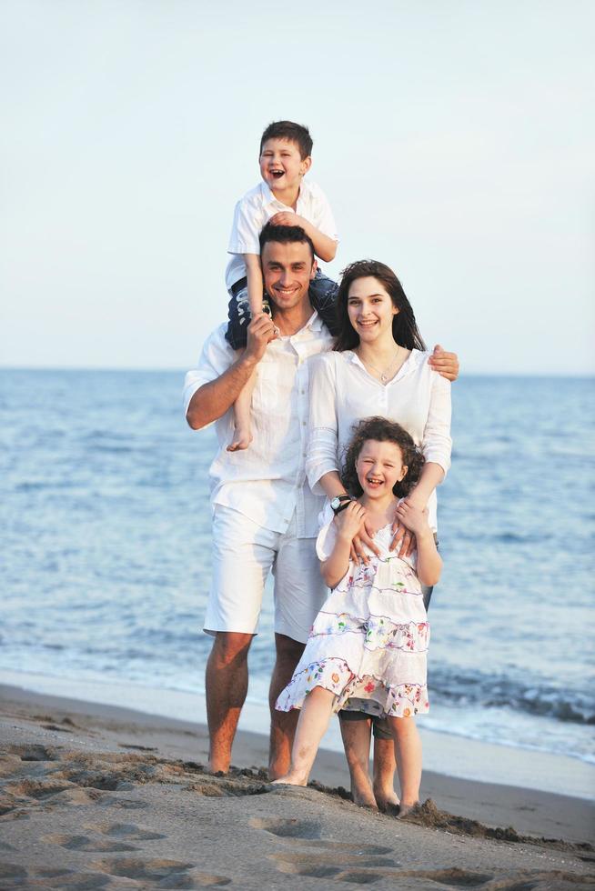 feliz jovem família se divertir na praia foto