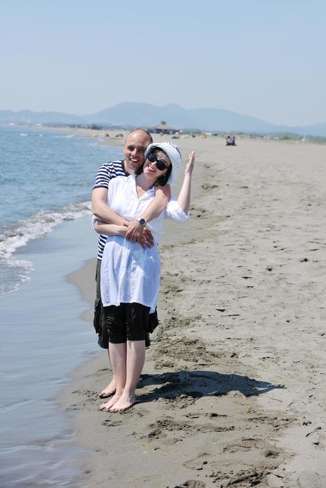 feliz casal jovem se divertir na praia foto