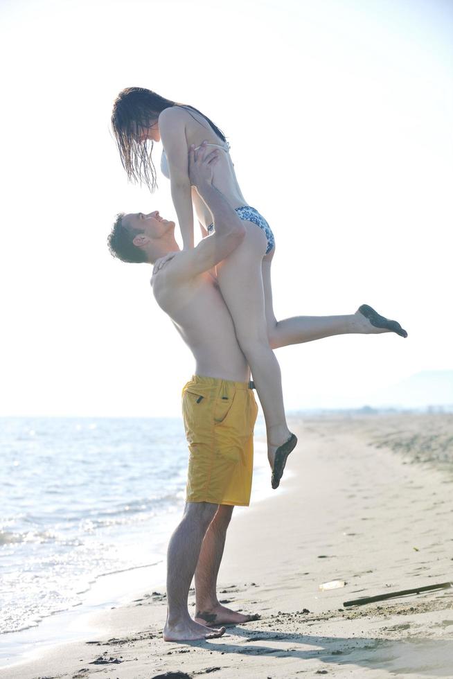 feliz casal jovem tem tempo romântico na praia foto