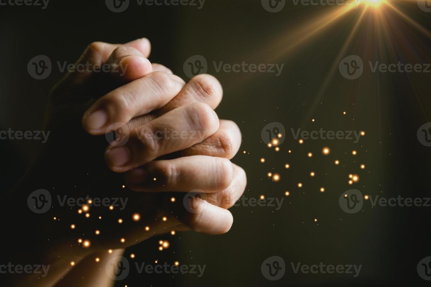 pessoa de oração mão em fundo preto. mulher católica cristã está orando a Deus no escuro na igreja. menina acreditar e fé em jesus cristo. religião de cristo e cristianismo adoram ou rezam o conceito. foto