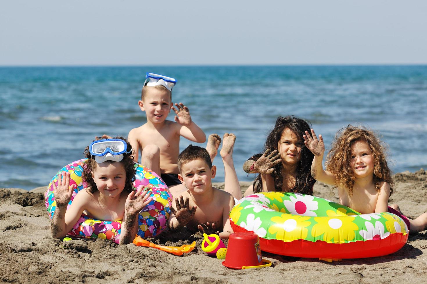 grupo infantil se diverte e brinca com brinquedos de praia foto