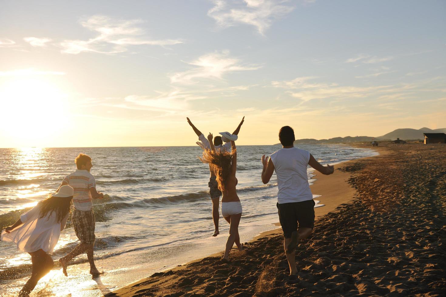 grupo de pessoas correndo na praia foto