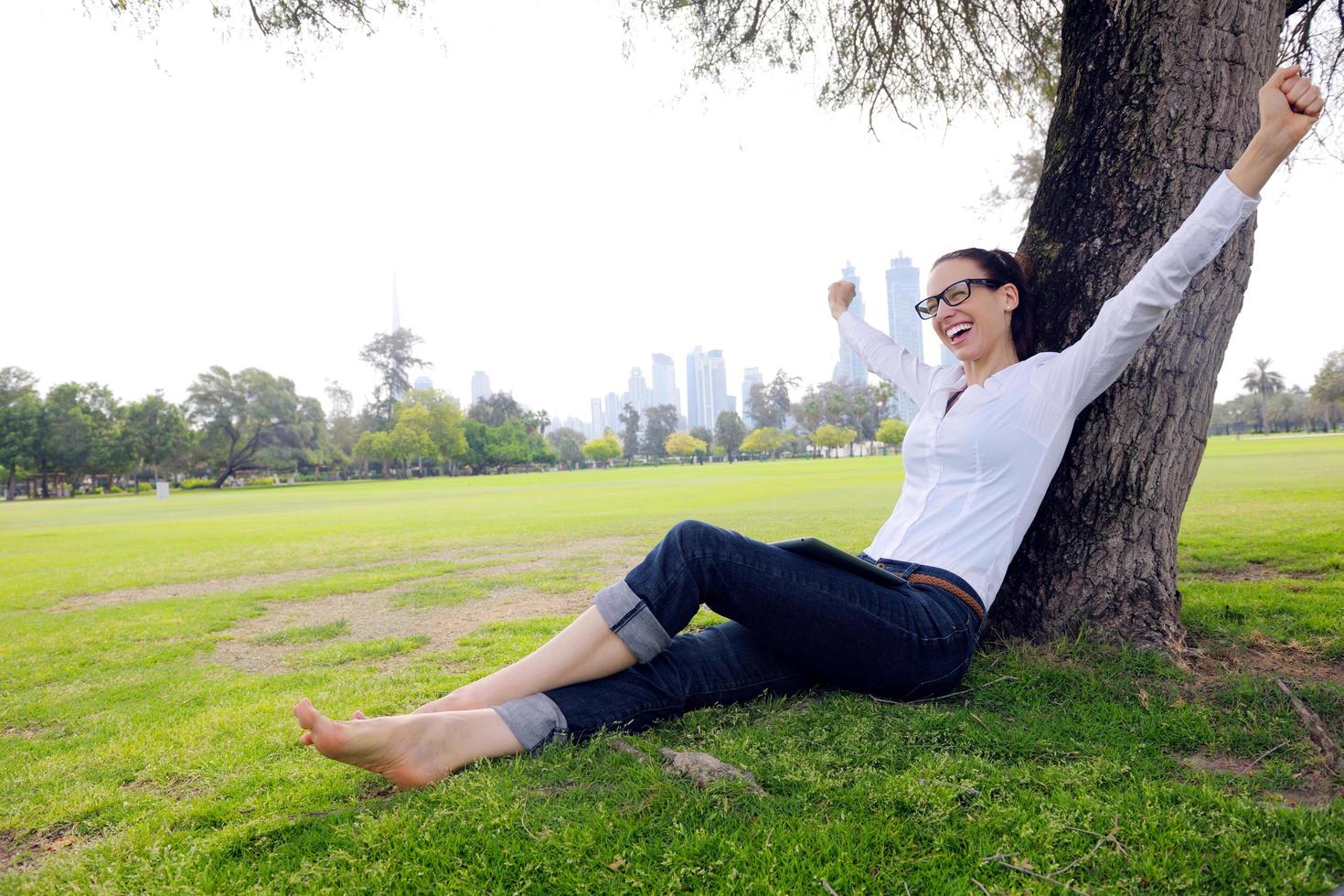 mulher jovem e bonita com tablet no parque foto