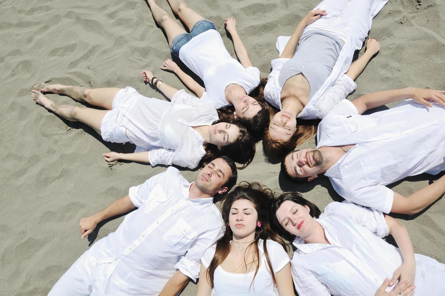 grupo de jovens felizes em se divertir na praia foto