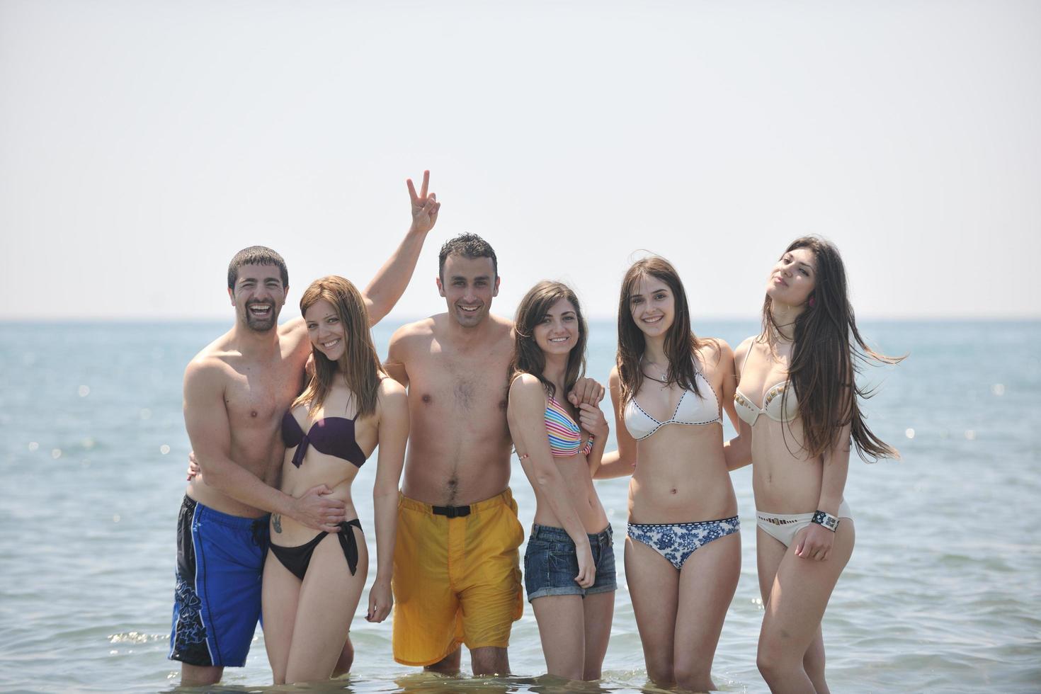 grupo de pessoas felizes se divertir e correr na praia foto