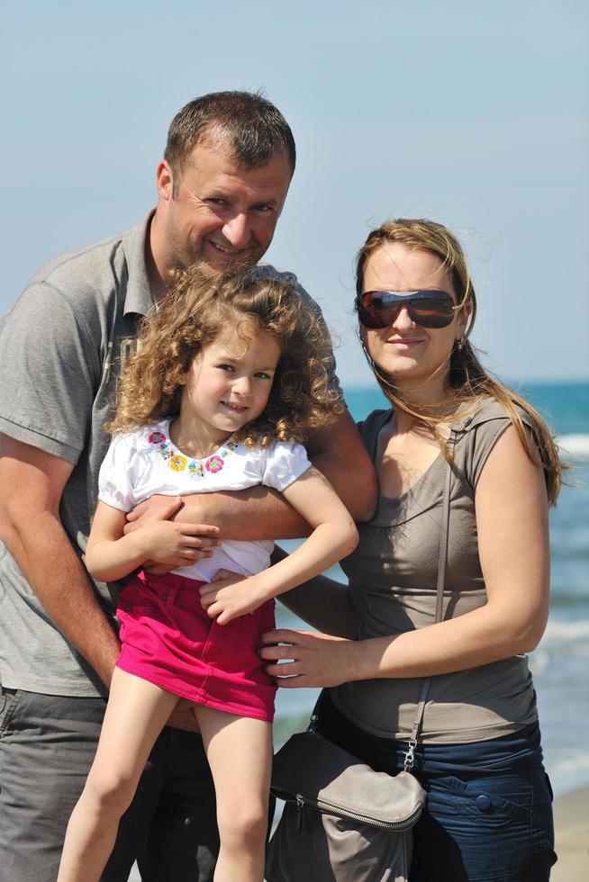 feliz jovem família se divertir na praia foto