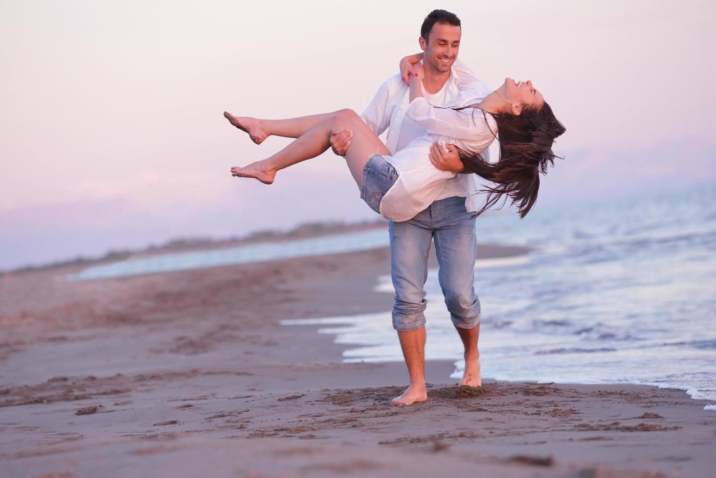 jovem casal na praia se divertir foto