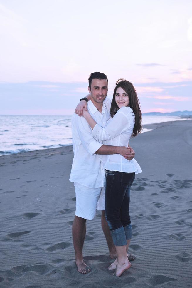 feliz casal jovem se divertir na praia foto