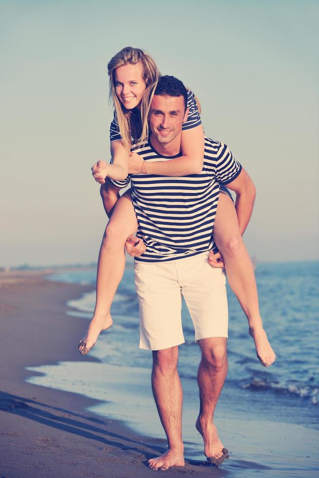 feliz casal jovem tem tempo romântico na praia foto