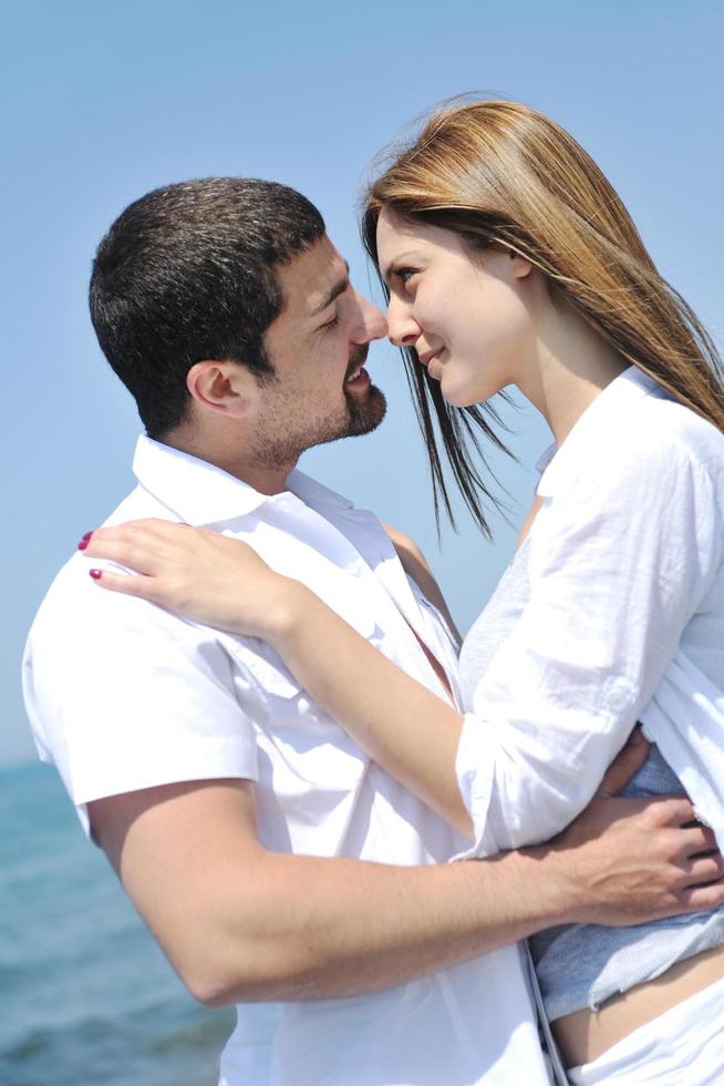 feliz casal jovem se divertir na praia foto