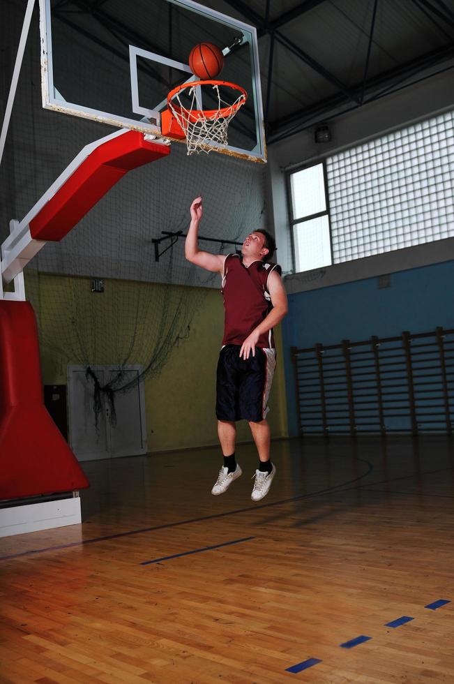 jogador de jogo de bola de basquete no pavilhão desportivo foto