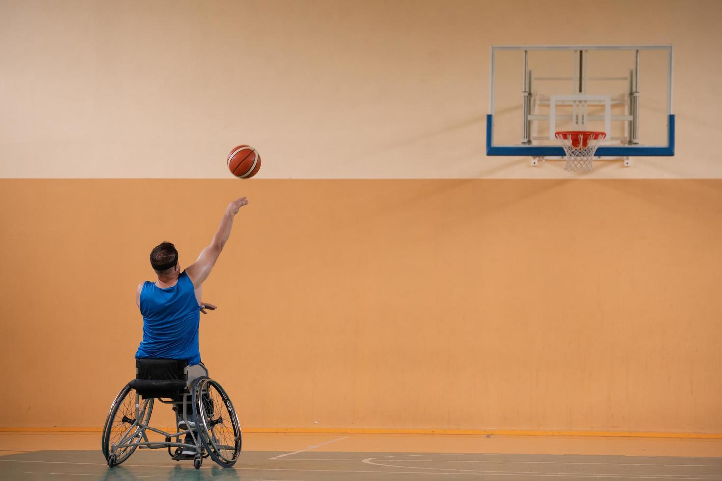 uma foto de um veterano de guerra jogando basquete com um time em uma arena esportiva moderna. o conceito de esporte para pessoas com deficiência