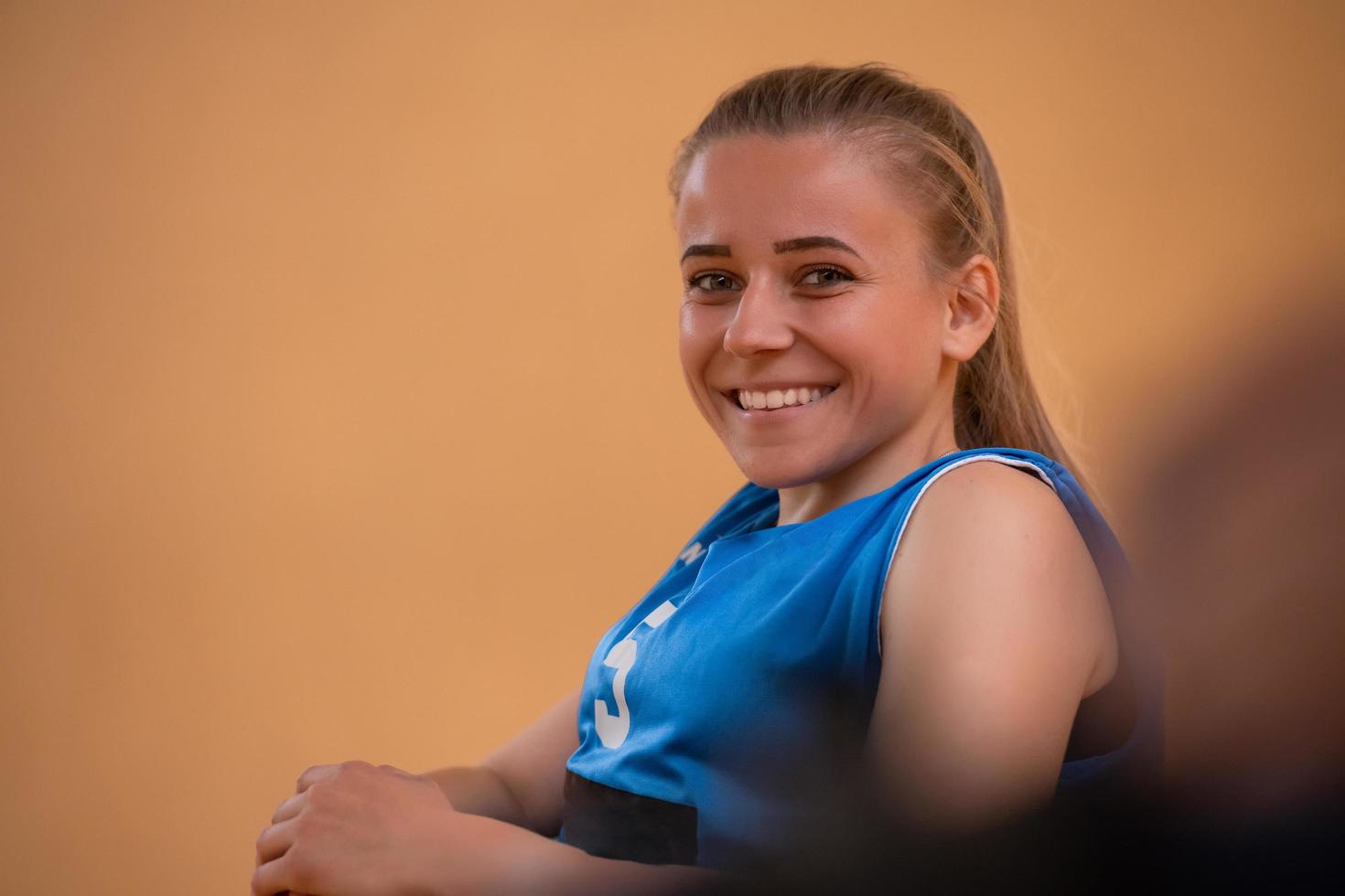 um retrato de uma mulher com deficiência sentada em uma cadeira de rodas esperando o início de um jogo de basquete foto