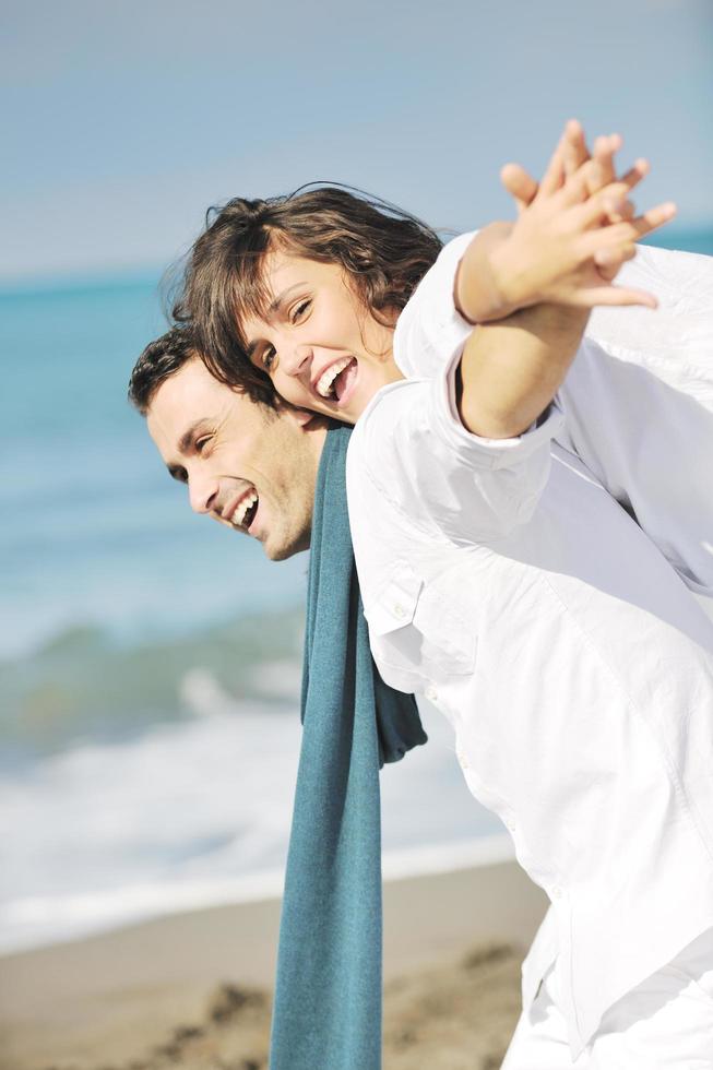 feliz casal jovem se diverte na bela praia foto