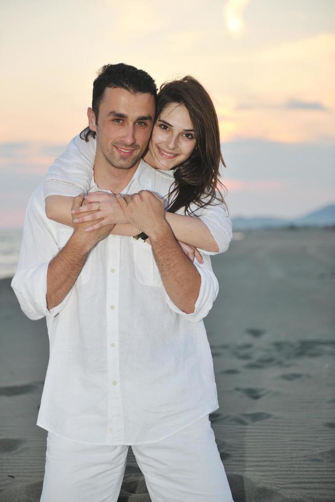 feliz casal jovem se divertir na praia foto